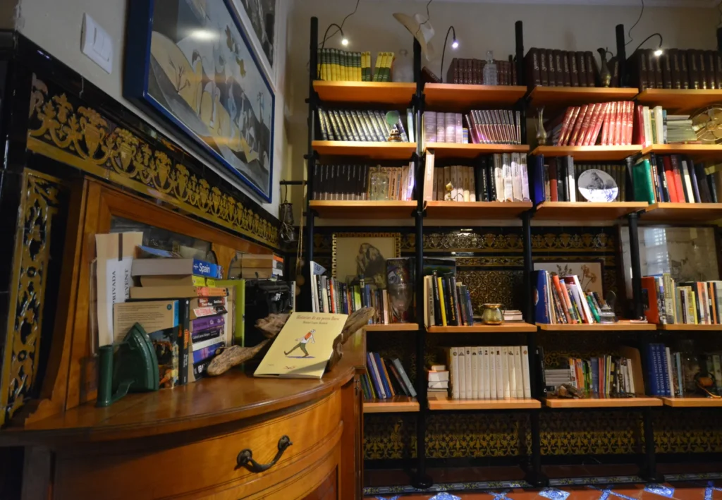 Biblioteca del hotel con estanterías y decoración artesanal · Casa de los Azulejos Hotel Boutique