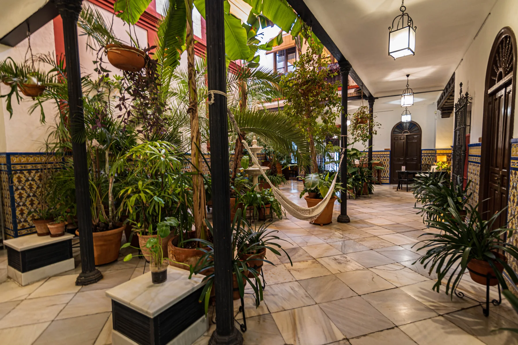 Patio central rodeado de vegetación y azulejos · Casa de los Azulejos Hotel Boutique