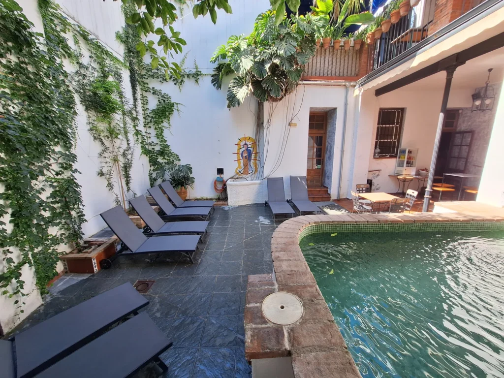 Piscina del hotel rodeada de vegetación · Casa de los Azulejos Hotel Boutique