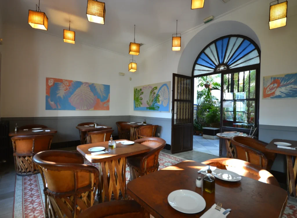 Salón de desayunos con mesas y ventanas al patio · Casa de los Azulejos Hotel Boutique